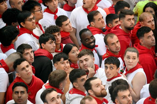 Participants crowd the street as they await the seventh running of the bulls of the San Fermin festival in Pamplona, northern Spain, on July 13, 2025. Thousands of people every year attend the week-long festival and its famous "encierros" or bull runs, every day at 8:00 a.m. through the narrow streets of the old town over an 850 meters (yard) course while runners ahead of them try to stay close to the bulls without falling over or being gored. (Photo by MIGUEL RIOPA / AFP)