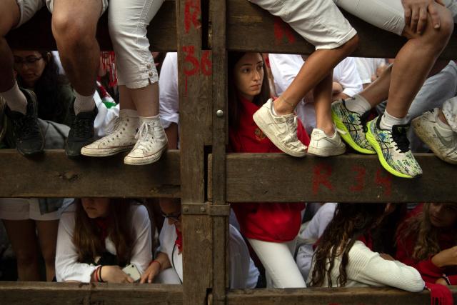 Revellers await the seventh running of the bulls of the San Fermin festival in Pamplona, northern Spain, on July 13, 2025. Thousands of people every year attend the week-long festival and its famous "encierros" or bull runs, every day at 8:00 a.m. through the narrow streets of the old town over an 850 meters (yard) course while runners ahead of them try to stay close to the bulls without falling over or being gored. (Photo by JORGE GUERRERO / AFP)