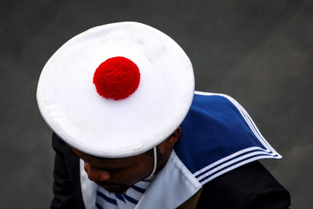 A French sailor wearing a navy ceremonial uniform, walks across the deck of the French patrol vessel Auguste Benebig, which will participate in the annual Talisman Sabre exercise, in Sydney on July 13, 2025. More than 30,000 military personnel from 19 nations are set to join in the annual Talisman Sabre exercise from Sunday across Australia and Papua New Guinea. (Photo by DAVID GRAY / AFP)