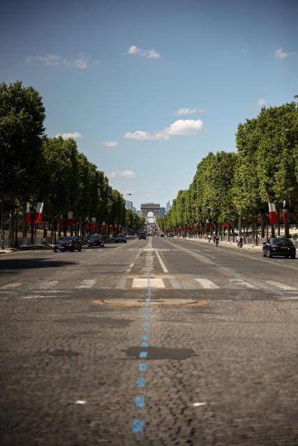 This photograph shows the Champs-Elysees Avenue with its trees decorated with French national flags in Paris on July 13, 2025, on the eve of the traditional annual Bastille day military parade. (Photo by Guillaume BAPTISTE / AFP)