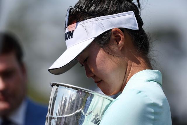 Australia's Grace Kim holds the trophy as she celebrates after victory on the first playoff hole after the final round of the Amundi Evian Championship at Evian Resort Golf Club, in Evian-Les-Bains, eastern France on July 13, 2025. (Photo by Alex MARTIN / AFP)