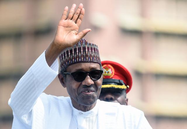 (FILES) Nigerian President Muhammadu Buhari salutes during an inspection of guards on parade to mark Democracy Day in Abuja, on June 12, 2019. Former Nigerian president Muhammadu Buhari -- who led his country first as a military strongman and later as an elected democrat -- died Sunday at the age of 82, an aide said. (Photo by PIUS UTOMI EKPEI / AFP)