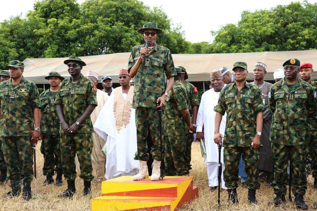(FILES) Nigeria's former military ruler President Mohammadu Buhari (C) flanked by service chiefs and other senior military officers, delivers a speech during the Army Day celebration in Dansadau, northwest Nigerian Zamfara State, on July 13, 2016. Former Nigerian president Muhammadu Buhari -- who led his country first as a military strongman and later as an elected democrat -- died Sunday at the age of 82, an aide said. (Photo by AFP)