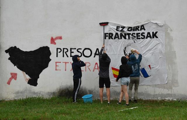 Young Basque independence supporters stick a banner on a wall reading "We are not French" during a demonstration against the celebration of July 14 in the Basque Country, called by the U14 collective (Uztailak 14-14 Juillet) in Espelette, southwestern France, on July 14, 2025. (Photo by Gaizka IROZ / AFP)