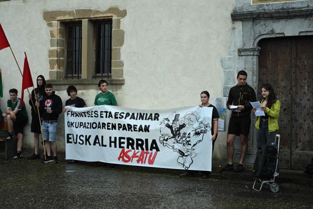 Young Basque independence supporters hold a banner reading "against the French and Spanish occupation let us liberate the Basque country" during a demonstration against the celebration of July 14 in the Basque Country, called by the U14 collective (Uztailak 14-14 Juillet) in Espelette, southwestern France, on July 14, 2025. (Photo by Gaizka IROZ / AFP)