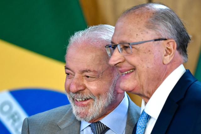 Brazil's President Luiz Inacio Lula da Silva (L) gestures as he talks with his Minister of Industry and Trade, Geraldo Alckmin, during the launch of a program to support taxi drivers at Planalto Palace in Brasilia on July 14, 2025. Luis Inácio Lula da Silva instructed his vice president and minister of industry and trade, Geraldo Alckmin, to form a commission with the sectors most affected by the 50% tariffs imposed by US President Donald Trump to negotiate with the US government in an attempt to prevent the tariffs from coming into effect on August 1. (Photo by EVARISTO SA / AFP)
