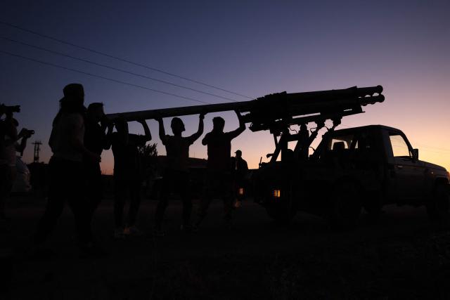 Members of Syria's security forces load a rocket launcher near the predominantly Druze city of Sweida on July 14, 2025, following clashes between Bedouin tribes and Druze fighters. Israeli Defence Minister Israel Katz issued a warning to Damascus on July 14 after the military struck several tanks in southern Syria to prevent them from reaching a Druze village near the scene of sectarian clashes. (Photo by Bakr ALKASEM / AFP)