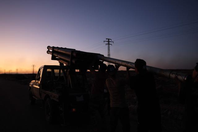 Members of Syria's security forces load a rocket launcher near the predominantly Druze city of Sweida on July 14, 2025, following clashes between Bedouin tribes and Druze fighters. Israeli Defence Minister Israel Katz issued a warning to Damascus on July 14 after the military struck several tanks in southern Syria to prevent them from reaching a Druze village near the scene of sectarian clashes. (Photo by Bakr ALKASEM / AFP)