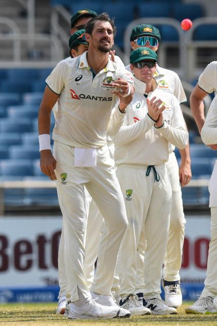 Mitchell Starc (L) of Australia throws the ball to the umpire after taking five wickets during the third day of the third Test cricket match between West Indies and Australia at Sabina Park in Kingston, Jamaica, on July 14, 2025. (Photo by Randy Brooks / AFP)