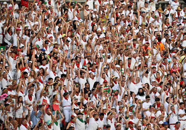 Revellers react during a bullfight at the San Fermin festival in Pamplona, northern Spain, on July 14, 2025. Thousands of people every year attend the week-long festival and its famous "encierros" or bull runs, every day at 8:00 a.m. through the narrow streets of the old town over an 850 meters (yard) course while runners ahead of them try to stay close to the bulls without falling over or being gored. (Photo by ANDER GILLENEA / AFP)