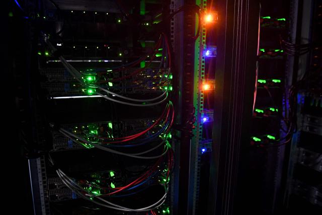 (FILES) A photograph taken on July 9, 2021 shows cables and serveres in the computers room at the Scaleway data center a subsidiary of the French Free wireless service provider group, in Saint-Ouen-l'Aumone. In a scramble to quickly bring more data centers online, US cloud computing giants are now getting directly involved in energy production. And while they are using some renewable energy options and trying to revive nuclear power, they are also turning to fossil fuels like gas, which in the United States is relatively cheap. A fight in Davis, in the woods of rural West Virginia, is the latest example of the war between the US tech sector -- and its rapidly rising need for energy to power the AI boom -- and the communities it affects. (Photo by ALAIN JOCARD / AFP)