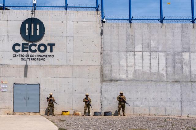 (FILES) Soldiers stand guard as unseen US Secretary of Homeland Security Kristi Noem tours the Terrorist Confinement Center (CECOT) in Tecoluca, El Salvador, on March 26, 2025. A small group of overstretched and outmatched lawyers are fighting for the rights of US deportees held at a notorious Salvadoran jail -- a David vs Goliath battle that may yet end up in international courts. (Photo by Alex Brandon / POOL / AFP)