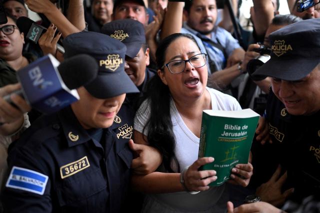 (FILES) Salvadoran lawyer and human rights activist Ruth Lopez is escorted by police to a hearing at the Isidro Menéndez judicial centre in San Salvador on June 4, 2025. A small group of overstretched and outmatched lawyers are fighting for the rights of US deportees held at a notorious Salvadoran jail -- a David vs Goliath battle that may yet end up in international courts. (Photo by Marvin RECINOS / AFP)