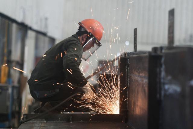 An employee works at a factory which produces steel structures in Hangzhou, in China’s eastern Zhejiang province on July 15, 2025. China's economy grew by 5.2 percent in the second quarter of the year, official data showed on July 15, matching forecasts as strong exports helped it withstand trade war pressures. (Photo by AFP) / China OUT