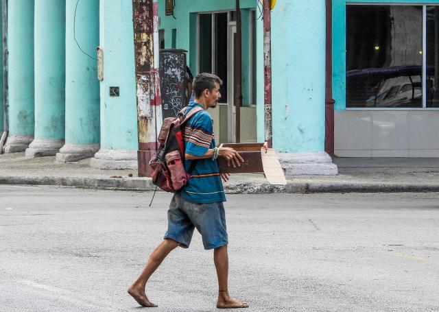 A beggar walks in a street of Havana to collect money from car drivers, on July 15, 2025. Begging in Cuba is associated with extreme poverty, family neglect, and mental health issues, and although the authorities minimize the phenomenon, citizens demand that it be recognized in order to address it. (Photo by ADALBERTO ROQUE / AFP)