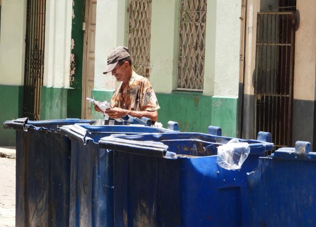 A man rummages through a dumpster in Havana, on July 15, 2025. Begging in Cuba is associated with extreme poverty, family neglect, and mental health issues, and although the authorities minimize the phenomenon, citizens demand that it be recognized in order to address it. (Photo by ADALBERTO ROQUE / AFP)