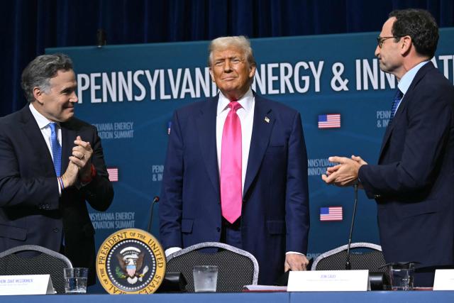 US President Donald Trump (C) is applauded by US Senator Dave McCormick (R-PA) and CEO of Blackstone Group Jon Gray (R) as he arrives for the Pennsylvania Energy and Innovation Summit on the campus of Carnegie Mellon University in Pittsburgh, Pennsylvania on July 15, 2025. (Photo by ANDREW CABALLERO-REYNOLDS / AFP)