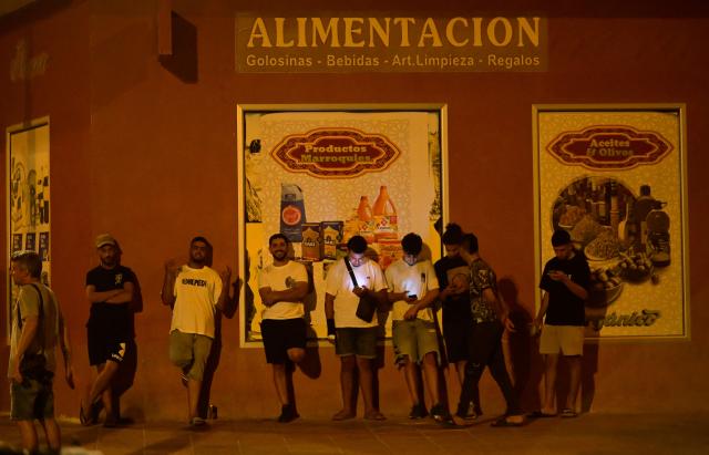 Youngsters stand in San Antonio district in Torre Pacheco, southeastern Spain, on July 15, 2025 as a rally has been called by far-right groups following four days of anti-migrant unrest. Spanish police have arrested nine people over rare anti-migrant unrest that rocked the town of Torre Pacheco, authorities said on July 14. Three nights of violence erupted on July 11 after a 68-year-old man told local media three youths of North African origin had beaten him up in the street of the southeastern town. (Photo by JOSE JORDAN / AFP)