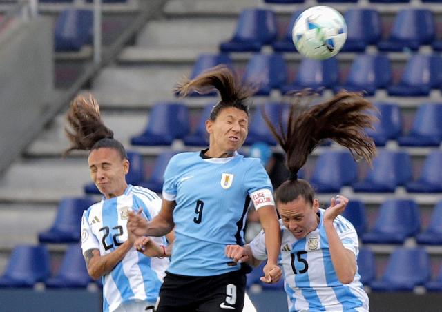 Uruguay's midfielder #09 Pamela Gonzalez jumps for a header with Argentina's forward #22 Betina Soriano and Argentina's defender #15 Maria Bonsegundo during the Women's Copa America 2025 football match between Uruguay and Argentina at the Independiente del Valle complex in Quito on July 15, 2025. (Photo by ARMANDO PRADO / AFP)