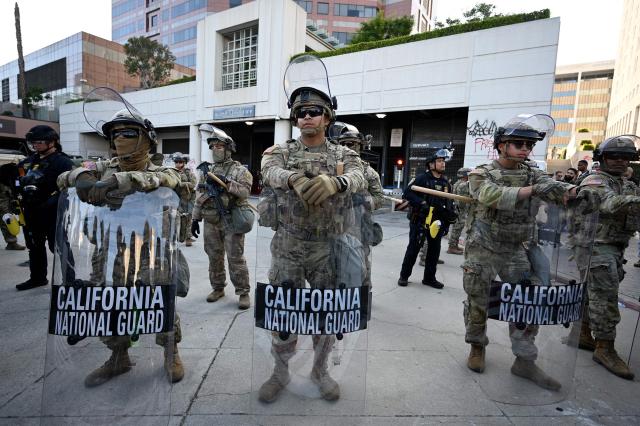 (FILES) Members of the California National Guard stand guard at the loading dock of the Roybal Federal Building in downtown Los Angeles, on June 12, 2025. US Defense Secretary Pete Hegseth has ordered the withdrawal of 2,000 National Guard troops from Los Angeles, roughly halving the contentious deployment in the city, the Pentagon said on July 15, 2025. President Donald Trump ordered thousands of National Guard and hundreds of Marines into Los Angeles last month in response to protests over federal immigration sweeps -- a move opposed by city leaders and California's Democratic Governor Gavin Newsom. (Photo by Robyn Beck / AFP)