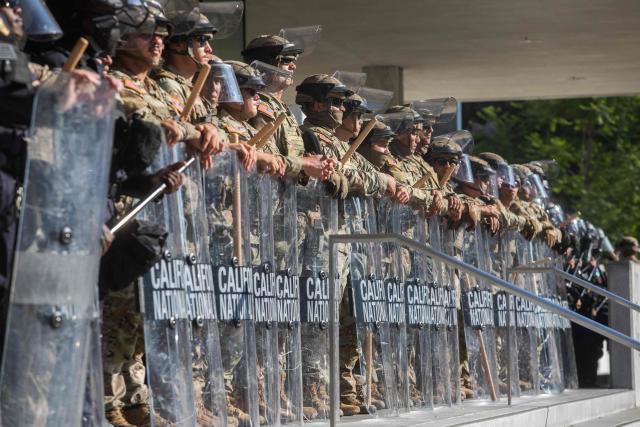 (FILES) California National Guard members stand guard outside the Federal Building as protests continue in response to federal immigration operations in Los Angeles on June 10, 2025. US Defense Secretary Pete Hegseth has ordered the withdrawal of 2,000 National Guard troops from Los Angeles, roughly halving the contentious deployment in the city, the Pentagon said on July 15, 2025. President Donald Trump ordered thousands of National Guard and hundreds of Marines into Los Angeles last month in response to protests over federal immigration sweeps -- a move opposed by city leaders and California's Democratic Governor Gavin Newsom. (Photo by Apu GOMES / AFP)