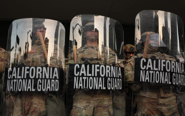 (FILES) California National Guard stand on the steps of the Federal Building after days of protests in response to federal immigration operations in Los Angeles on June 10, 2025. US Defense Secretary Pete Hegseth has ordered the withdrawal of 2,000 National Guard troops from Los Angeles, roughly halving the contentious deployment in the city, the Pentagon said on July 15, 2025. President Donald Trump ordered thousands of National Guard and hundreds of Marines into Los Angeles last month in response to protests over federal immigration sweeps -- a move opposed by city leaders and California's Democratic Governor Gavin Newsom. (Photo by Patrick T. Fallon / AFP)