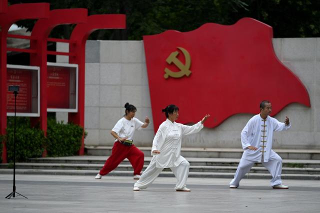 People practise Taichi at a square in Beijing on July 16, 2025. (Photo by WANG Zhao / AFP)