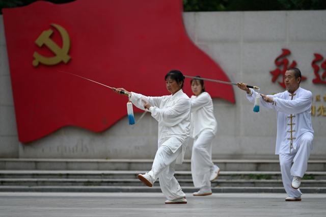 People practise Taichi at a square in Beijing on July 16, 2025. (Photo by WANG Zhao / AFP)