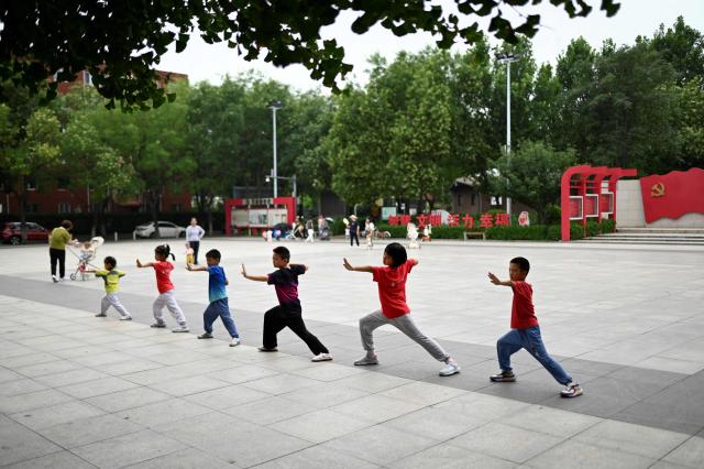A group of children practise Chinese martial at a square in Beijing on July 16, 2025. (Photo by WANG Zhao / AFP)