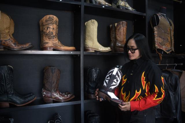 Etnawati Melani, the owner and designer of Tegep Boots, a popular Indonesian handmade leather boots maker with many dedicated customers in the United States and Europe, poses at the shop's showroom in Bandung, West Java on July 15, 2025. At a leather boot shop in the Indonesian city of Bandung, workers handle an order from Texas but owner Etnawati Melani says she fears such business will dwindle when US president Donald Trump's tariffs hit exports. (Photo by Timur MATAHARI / AFP) / TO GO WITH AFP STORY: Indonesia-economy-trade-US, by Yuli Krisna