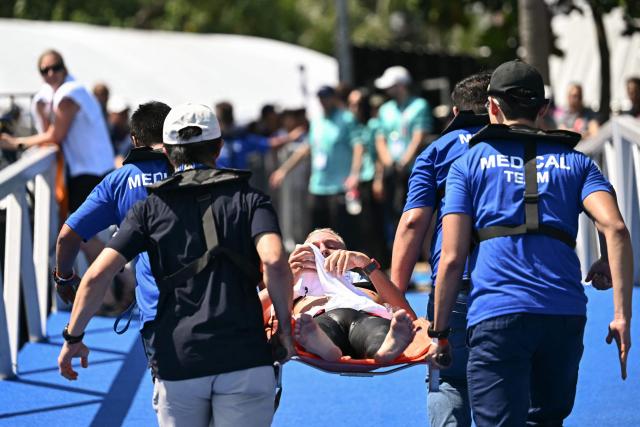A medical team carries France's swimmer Marc-Antoine Olivier on a stretcher after he was pulled out from the water in the final of the men's 10km open water swimming event during the 2025 World Aquatics Championships at Sentosa Island in Singapore on July 16, 2025. (Photo by Manan VATSYAYANA / AFP)
