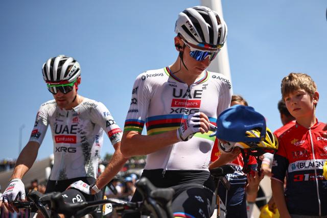 UAE Team Emirates - XRG team's Slovenian rider Tadej Pogacar signs autographs, flanked by UAE Team Emirates - XRG team's French rider Pavel Sivakov (L) before the start of the 11th stage of the 112th edition of the Tour de France cycling race, 156.8 km starting and finishing in Toulouse, southwestern France, on July 16, 2025. (Photo by Anne-Christine POUJOULAT / AFP)