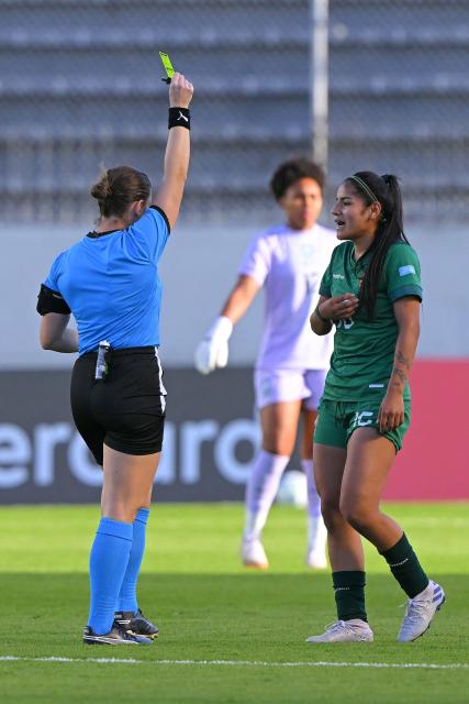 Argentine referee Roberta Echeverria shows a yellow card to Bolivia's defender #16 Anabel Flores during the Women's Copa America 2025 football match between Bolivia and Brazil at the Gonzalo Pozo Ripalda stadium in Quito on July 16, 2025. (Photo by Rodrigo BUENDIA / AFP)
