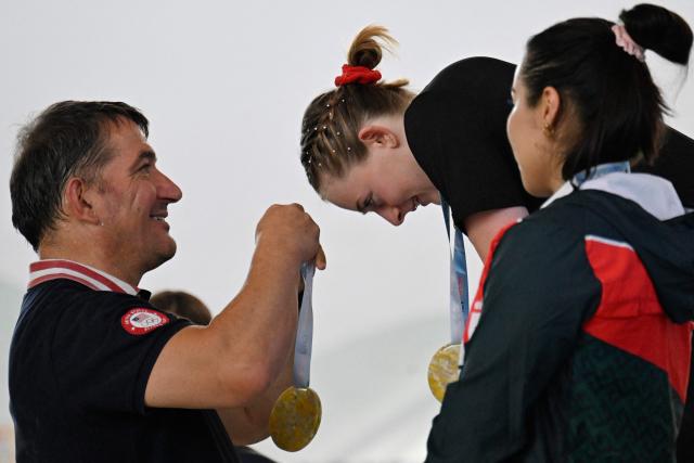 US' Olivia Lynn (C) and Mexico's Diana Garcia are pictured at the 69 kg medal ceremony during the 2025 Pan American Weightlifting Championships at Miguel Calero Coliseum in Cali, Colombia on July 16, 2025. (Photo by JOAQUIN SARMIENTO / AFP)
