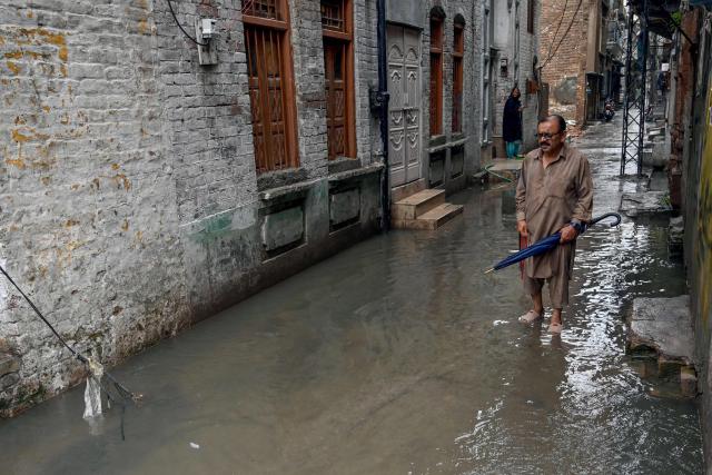A man wades through a flooded street amidst heavy monsoon rains in Rawalpindi on July 17, 2025. Heavy rains have been linked to 54 deaths in the past 24 hours in Pakistan, taking the toll to about 180 since the arrival of the monsoon in late June, the government's disaster agency said on July 17. (Photo by Farooq NAEEM / AFP)