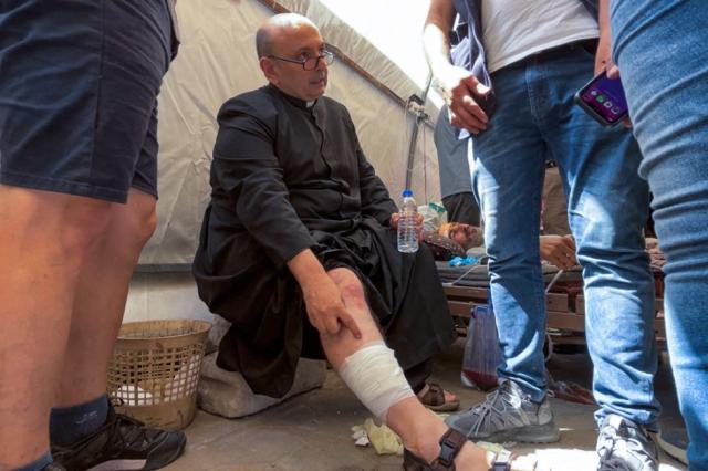 Parish Priest of the Holy Family church in Gaza City Fr. Gabriel Romanelli receives care after he was injured in an Israeli strike on the church, at the city's Arab Ahli, also known as Baptist, hospital on July 17, 2025. The Latin Patriarchate of Jerusalem said an Israeli strike on Gaza's only Catholic church injured several people on July 17, including the parish priest, as well as causing damage to the building. (Photo by Omar AL-QATTAA / AFP)