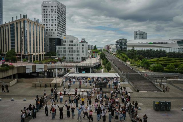 Young people participate in a mass dancing event at the La Defense business district, on the western outskirts of Paris on July 17, 2025. (Photo by Dimitar DILKOFF / AFP)