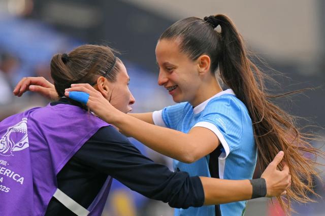 Uruguay's forward #10 Belen Aquino (R) celebrates with a teammate after scoring his team's first goal during the Women's Copa America 2025 football match between Uruguay and Peru at the IDV stadium in Quito on July 18, 2025. (Photo by Rodrigo BUENDIA / AFP)