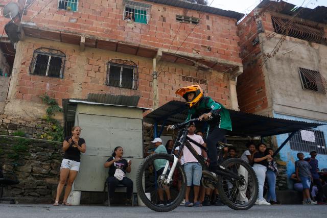A downhill rider participates in the Petare en Alta urban downhill competition in Petare, Miranda state, Venezuela on July 18, 2025. (Photo by Pedro MATTEY / AFP)