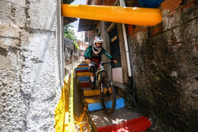 A downhill rider participates in the Petare en Alta urban downhill competition in Petare, Miranda state, Venezuela on July 18, 2025. (Photo by Pedro MATTEY / AFP)