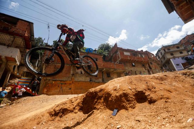 A downhill rider participates in the Petare en Alta urban downhill competition in Petare, Miranda state, Venezuela on July 18, 2025. (Photo by Pedro MATTEY / AFP)