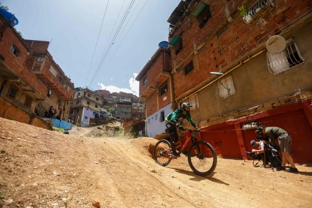 A downhill rider participates in the Petare en Alta urban downhill competition in Petare, Miranda state, Venezuela on July 18, 2025. (Photo by Pedro MATTEY / AFP)