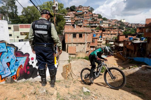 A downhill rider participates in the Petare en Alta urban downhill competition in Petare, Miranda state, Venezuela on July 18, 2025. (Photo by Pedro MATTEY / AFP)