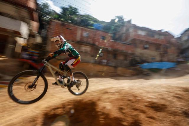 A downhill rider participates in the Petare en Alta urban downhill competition in Petare, Miranda state, Venezuela on July 18, 2025. (Photo by Pedro MATTEY / AFP)