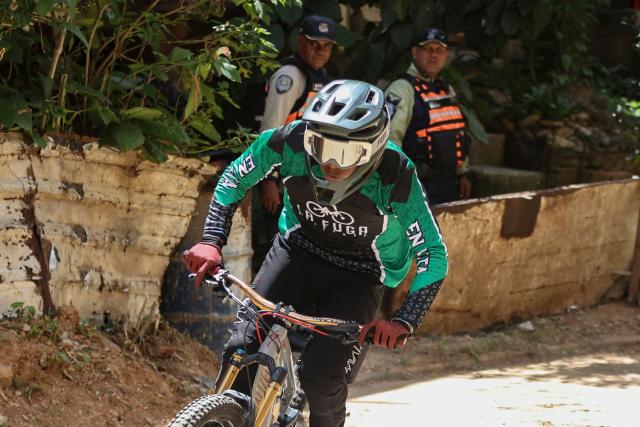 A downhill rider participates in the Petare en Alta urban downhill competition in Petare, Miranda state, Venezuela on July 18, 2025. (Photo by Pedro MATTEY / AFP)