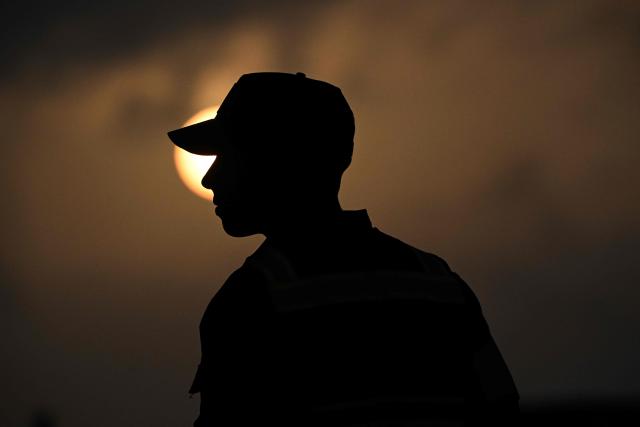 A members of Venezuelan authorities guards the arrival of a plane carrying Venezuelan migrants jailed in El Salvador during sundown at Simon Bolivar International Airport in Maiquetia, Venezuela on July 18, 2025. El Salvador freed scores of Venezuelans deported from the United States to a notorious maximum security prison, the outcome of a highly coordinated prisoner swap between Caracas and Washington on July 18, 2025. (Photo by Federico PARRA / AFP)