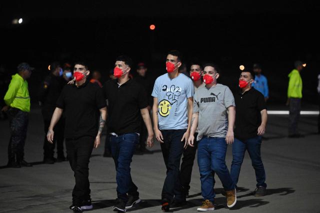 Venezuelan migrants who were jailed in El Salvador walk upon arrival at Simon Bolivar International Airport in Maiquetia, Venezuela on July 18, 2025. El Salvador freed scores of Venezuelans deported from the United States to a notorious maximum security prison, the outcome of a highly coordinated prisoner swap between Caracas and Washington on July 18, 2025. (Photo by Federico PARRA / AFP)