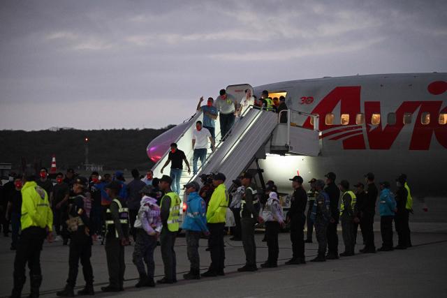 Venezuelan migrants who were jailed in El Salvador walk upon arrival at Simon Bolivar International Airport in Maiquetia, Venezuela on July 18, 2025. El Salvador freed scores of Venezuelans deported from the United States to a notorious maximum security prison, the outcome of a highly coordinated prisoner swap between Caracas and Washington on July 18, 2025. (Photo by Federico PARRA / AFP)