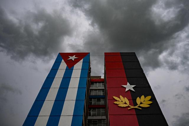 A 26th of July Movement flag painted on a building is seen in tribute to the 72nd anniversary of the assault on the Moncada Barracks in 1953, in Ciego de Avila province, Cuba on July 23, 2025. The Cuban government on July 26 will commemorate the 72nd anniversary of the guerrilla assault on the Moncada Barracks, widely regarded as the beginning of the Cuban Revolution. (Photo by YAMIL LAGE / AFP)