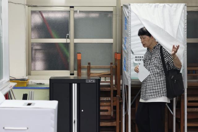A voter leaves a booth during voting for the recall election at a polling station in Taipei on July 26, 2025. Taiwanese voters turned out at schools, churches and community centres on July 26 to cast their ballot in a high-stakes recall election that could give President Lai Ching-te's party control of the parliament. (Photo by I-Hwa Cheng / AFP)